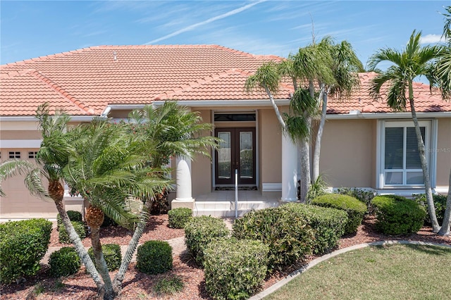 back of property featuring french doors and a garage