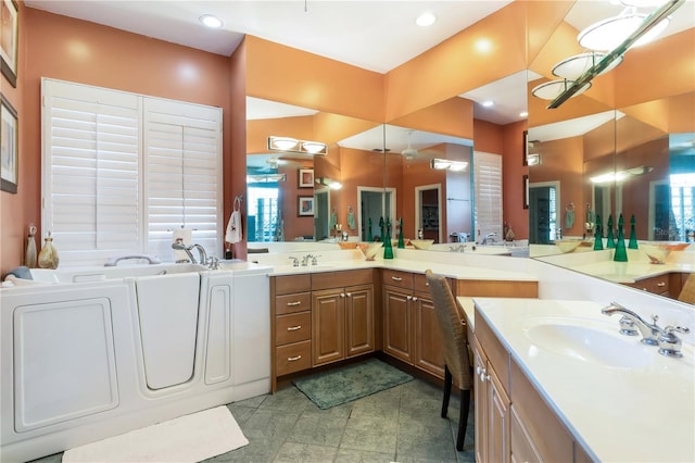 bathroom featuring washing machine and clothes dryer, tile floors, vanity, and a bath to relax in