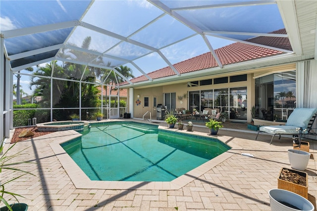 view of pool featuring a lanai, area for grilling, a patio area, and an in ground hot tub