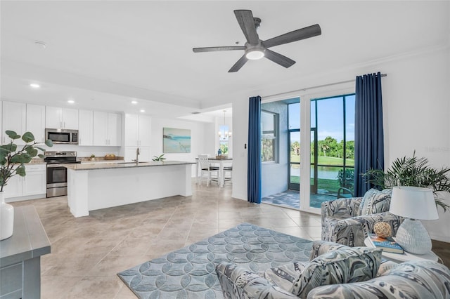 living room with sink, crown molding, ceiling fan, and light tile floors