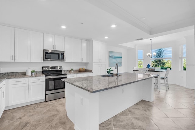 kitchen featuring white cabinets, sink, stainless steel appliances, a center island with sink, and light stone countertops