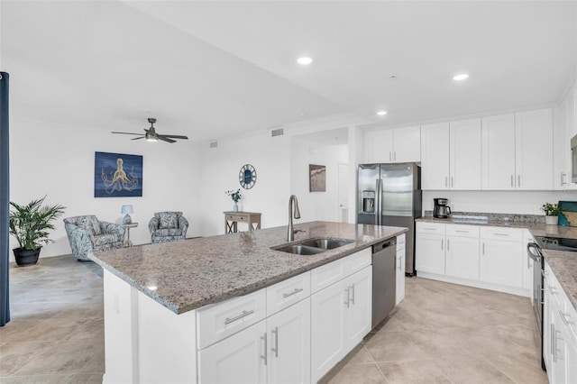 kitchen with sink, ceiling fan, white cabinetry, and a kitchen island with sink