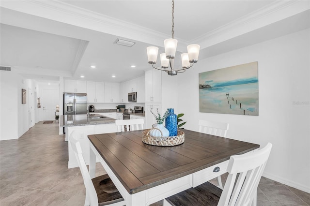 dining area featuring light tile floors, sink, a raised ceiling, a chandelier, and ornamental molding