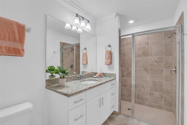 bathroom featuring tile floors, vanity, ornamental molding, a shower with shower door, and toilet