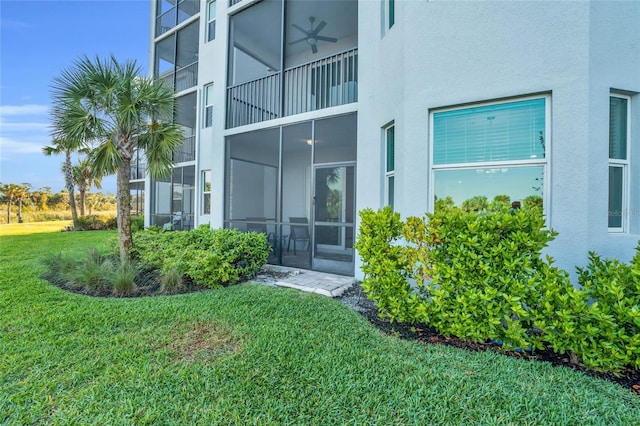 property entrance with a balcony and a lawn