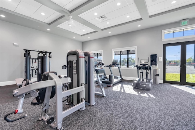 exercise room with french doors, dark carpet, coffered ceiling, and a towering ceiling