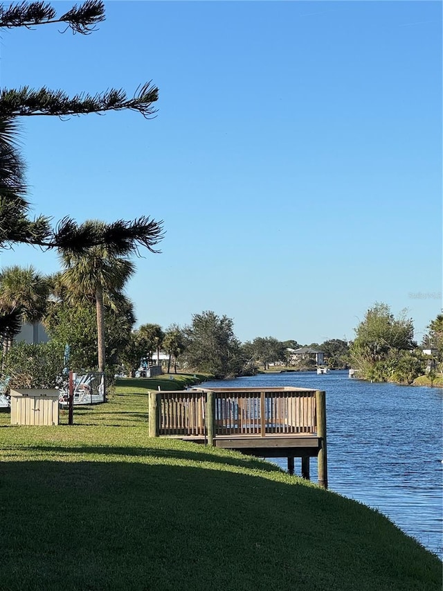 dock area with a lawn and a water view