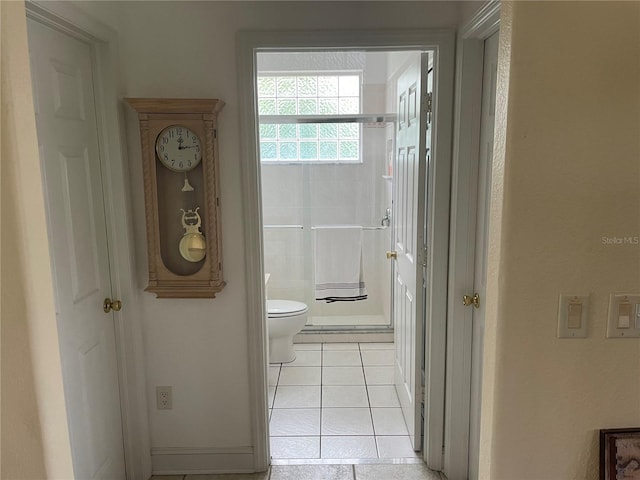 bathroom with toilet, tile patterned flooring, and a shower with shower door