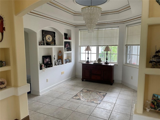 interior space with built in shelves, light tile patterned floors, a chandelier, and ornamental molding