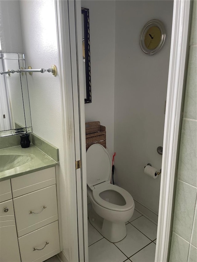 bathroom featuring toilet, tile patterned floors, and vanity