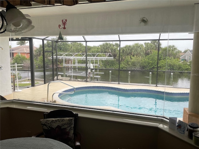 view of pool with a lanai, a water view, and a patio