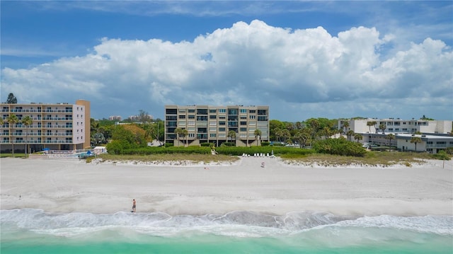 view of building exterior with a water view and a view of the beach