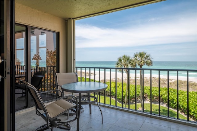 balcony featuring a water view and a view of the beach