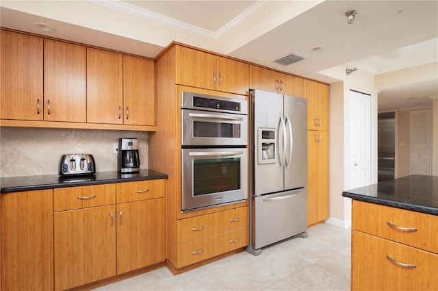 kitchen featuring ornamental molding, tasteful backsplash, dark stone counters, and appliances with stainless steel finishes