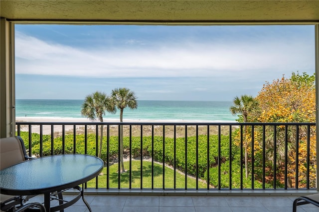 balcony with a water view and a view of the beach