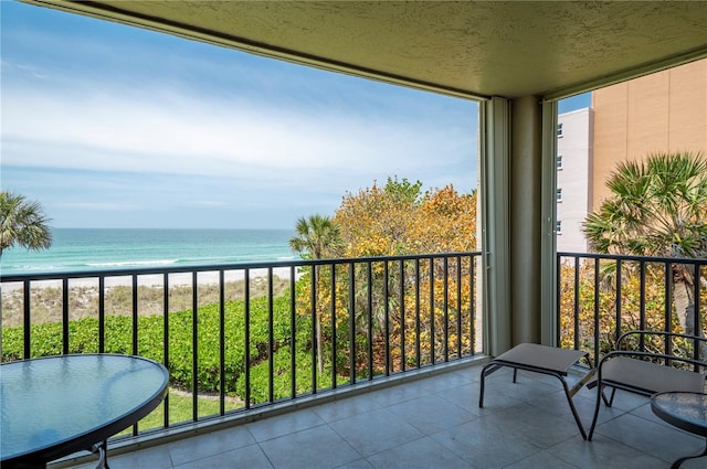 balcony featuring a beach view and a water view