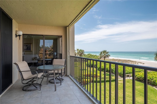 balcony with a water view and a view of the beach