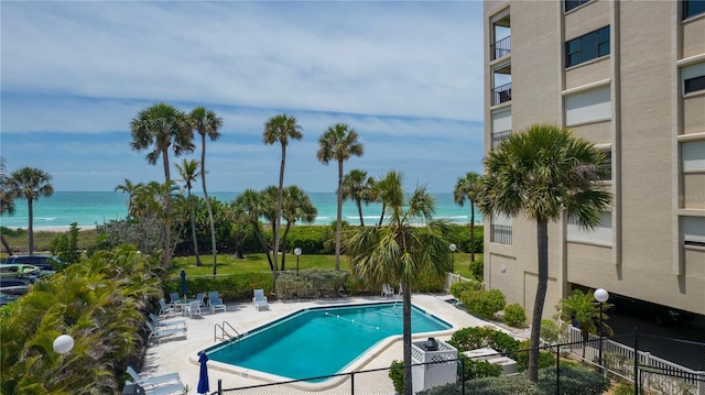 view of swimming pool featuring a water view and a patio