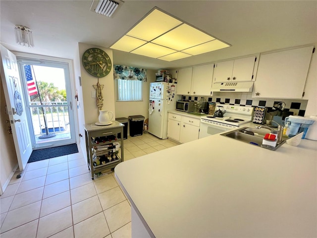 kitchen with sink, white cabinetry, light tile patterned floors, and white appliances