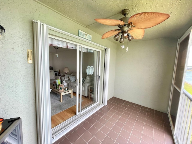 unfurnished sunroom with ceiling fan