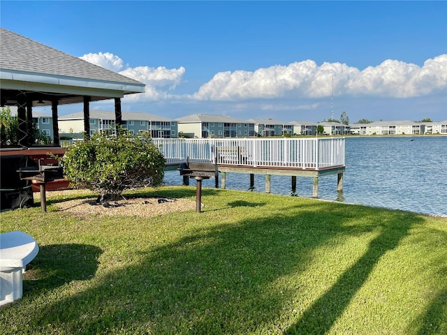 dock area with a water view and a yard