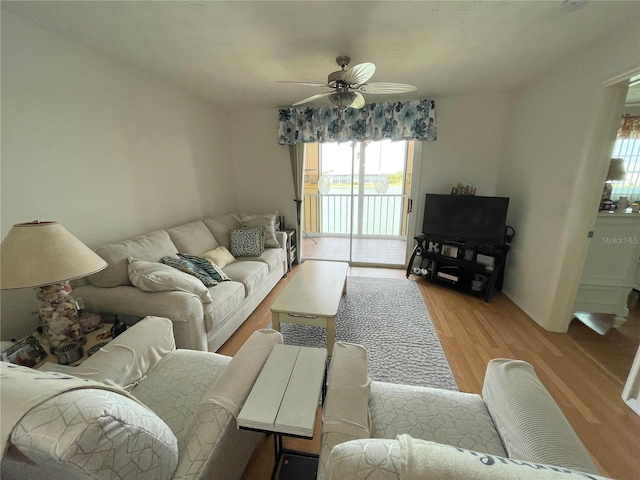 living room with light hardwood / wood-style flooring and ceiling fan