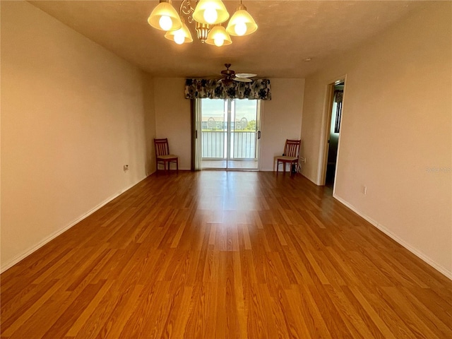 unfurnished room with hardwood / wood-style flooring and an inviting chandelier