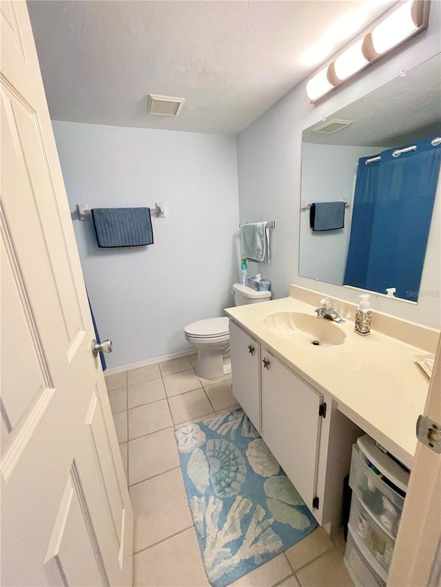 bathroom featuring vanity, tile patterned floors, and toilet