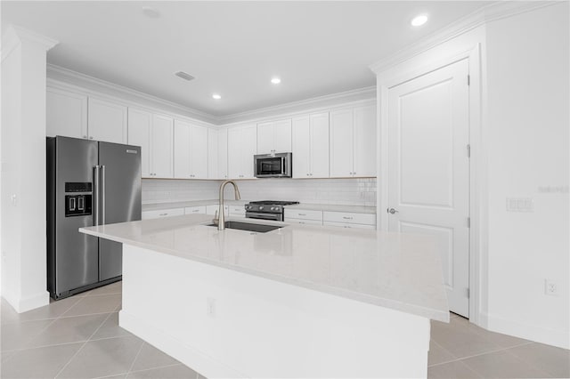 kitchen featuring sink, stainless steel appliances, white cabinetry, and a kitchen island with sink