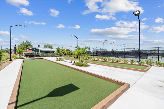 view of property's community with tennis court and a water view