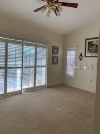 carpeted spare room with ceiling fan