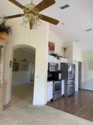 kitchen featuring dark wood-type flooring, lofted ceiling, ceiling fan, and appliances with stainless steel finishes