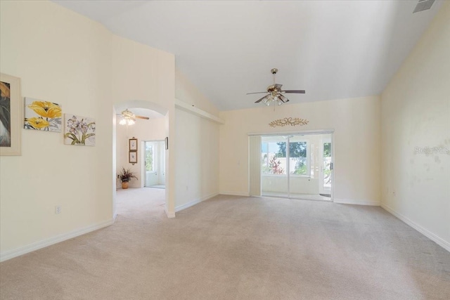 spare room with a wealth of natural light, light carpet, ceiling fan, and vaulted ceiling