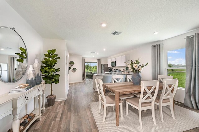 dining area with hardwood / wood-style flooring and a textured ceiling