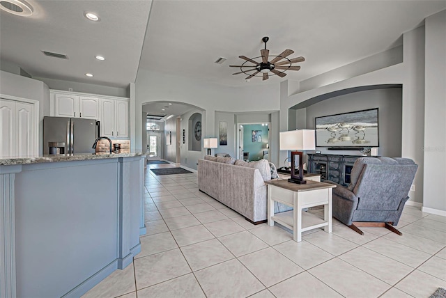 tiled living room with sink and ceiling fan