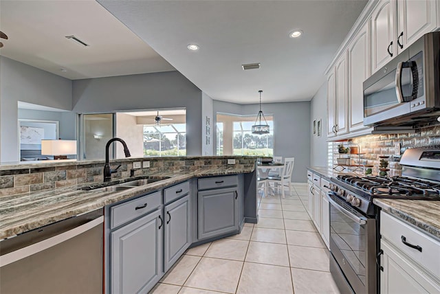 kitchen with white cabinetry, appliances with stainless steel finishes, sink, tasteful backsplash, and ceiling fan