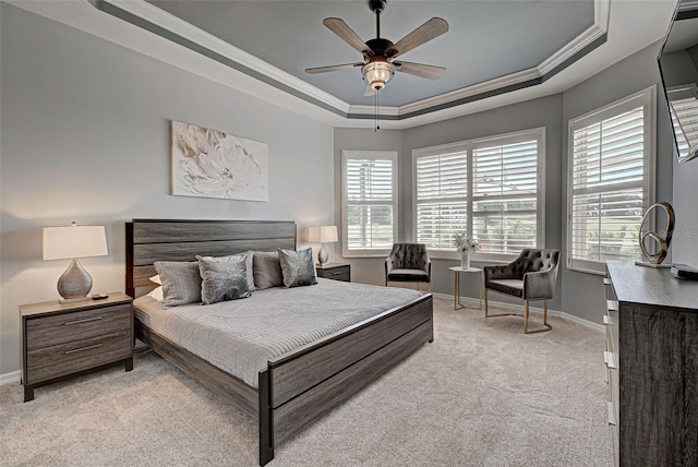 bedroom with light colored carpet, ceiling fan, a tray ceiling, and crown molding