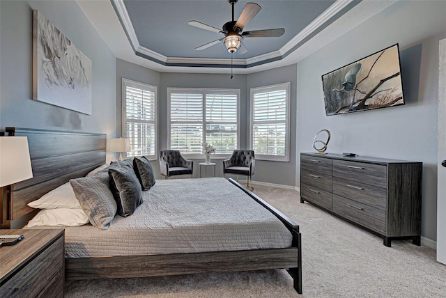 bedroom with light carpet, ceiling fan, crown molding, and a tray ceiling