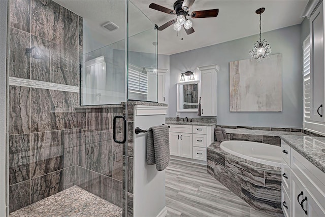 bathroom featuring independent shower and bath, ceiling fan, and vanity