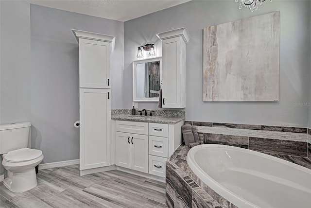 bathroom featuring a relaxing tiled bath, toilet, and large vanity