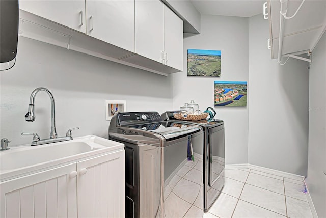 laundry room with cabinets, washing machine and clothes dryer, sink, light tile flooring, and hookup for a washing machine