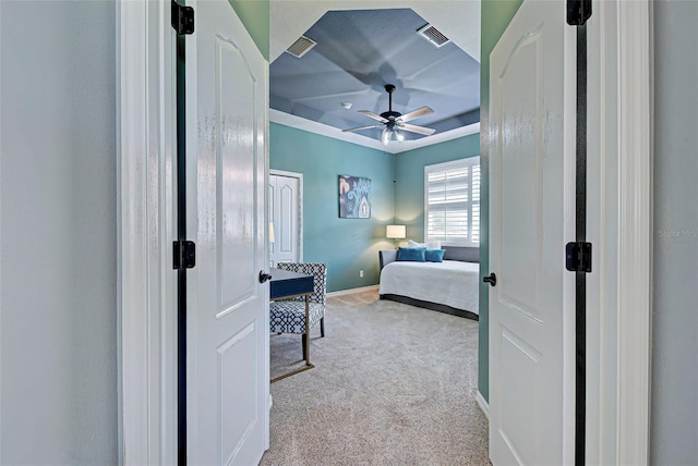 carpeted bedroom featuring a tray ceiling