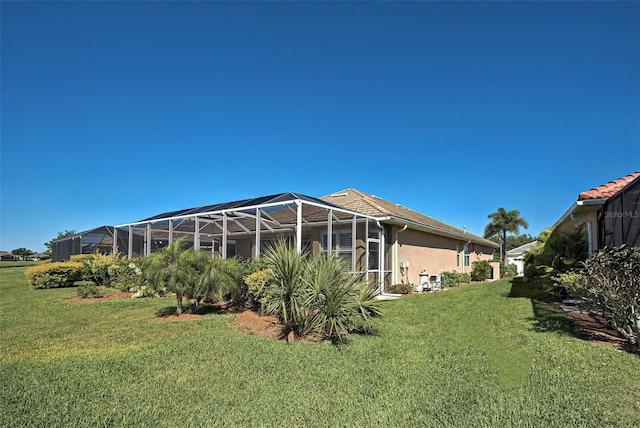 exterior space featuring glass enclosure and a lawn