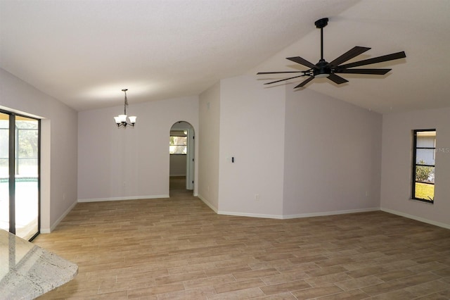 empty room with a wealth of natural light, vaulted ceiling, and light hardwood / wood-style floors