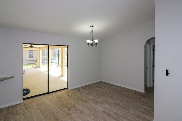 empty room featuring hardwood / wood-style floors and ceiling fan with notable chandelier