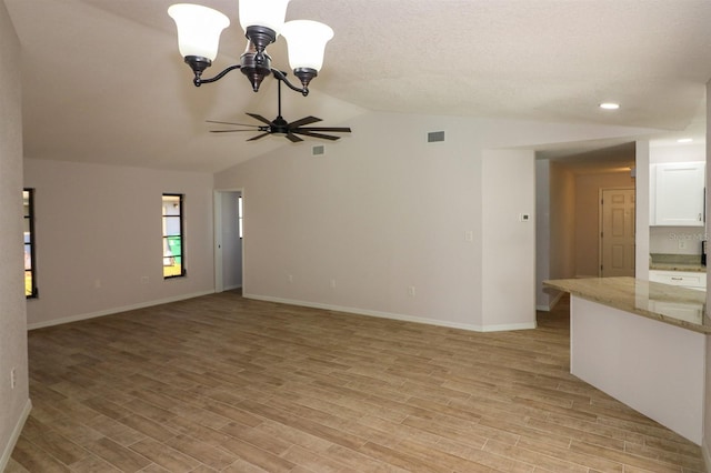 unfurnished room with lofted ceiling, light hardwood / wood-style floors, and ceiling fan with notable chandelier