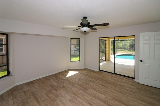 spare room with wood-type flooring, ceiling fan, and a textured ceiling