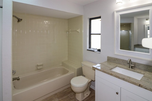 full bathroom featuring tiled shower / bath combo, toilet, and vanity with extensive cabinet space