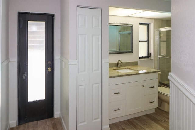 bathroom featuring oversized vanity, hardwood / wood-style flooring, and toilet