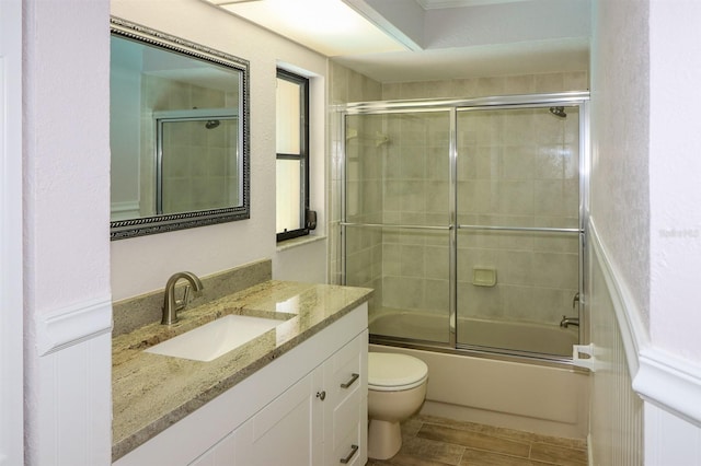 full bathroom with oversized vanity, toilet, and bath / shower combo with glass door